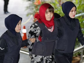Vietnamese Doan Thi Huong, centre, is escorted by police as she arrives at Shah Alam High Court in Shah Alam, Malaysia, Thursday, March 14, 2019.