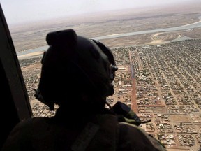 A French soldier stands inside a military helicopter during a visit by French President Emmanuel Macron to the troops of Operation Barkhane, France's largest overseas military operation, in Gao, northern Mali, Friday, May 19, 2017.