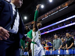 Boston Celtics' Marcus Smart gestures to the crowd as he is escorted off the court after committing a flagrant foul against Philadelphia 76ers' Joel Embiid during the second half of an NBA game Wednesday, March 20, 2019, in Philadelphia.