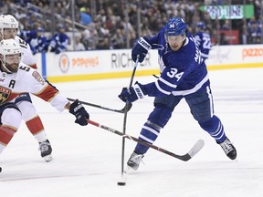 Maple Leafs centre Auston Matthews takes a shot as Florida Panthers defenceman Aaron Ekblad defends on Monday night at Scotiabank Arena. (Nathan Denette/The Canadian Press)