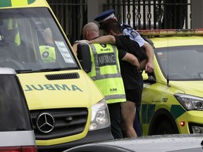Police and ambulance staff help a wounded man from outside a mosque in central Christchurch, New Zealand, Friday, March 15, 2019.