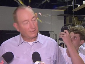 In this image made from video, a teen breaks an egg on the head of Australian Sen. Fraser Anning while he holds a press conference, Saturday, March 16, 2019, in Melbourne.
