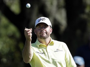In this March 15, 2014, file photo, Robert Garrigus looks at his golf ball during the third round of the Valspar Championship at Innisbrook in Palm Harbor, Fla.