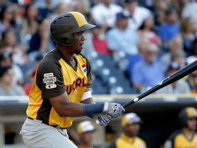 In this July 10, 2016, file photo, World Team's Eloy Jimenez hits against the U.S. Team during the seventh inning of the All-Star Futures baseball game in San Diego.
