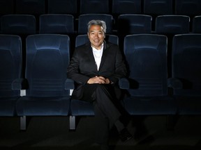 In this Feb. 6, 2013, file photo, Kevin Tsujihara, poses for photos in a screening room at the Warner Bros. Studios in Burbank, Calif.