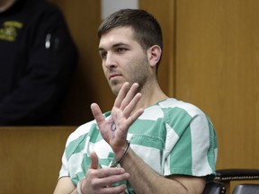 In this March 18, 2019, file photo, Anthony Comello displays writing on his hand that includes pro-Donald Trump slogans during his extradition hearing in Toms River, N.J.