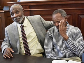 Nathan Myers, left, embraces his uncle, Clifford Williams, during a news conference after their 1976 murder convictions were overturned Thursday, March 28, 2019 in Jacksonville, Fla. (Will Dickey/The Florida Times-Union via AP)