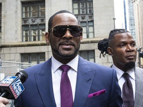 R. Kelly and his publicist Darryll Johnson, right, leave The Daley Center after an appearance in court for Kelly's child support case, Wednesday, March 13, 2019, in Chicago.
