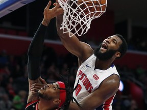 Detroit Pistons center Andre Drummond dunks on Toronto Raptors forward Eric Moreland in Detroit on Sunday. (AP)