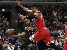 Raptors’ Norman Powell (left) passes the ball around Bulls’ Timothe Luwawu-Cabarrot during the first half in Chicago last night.