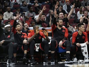 The Toronto Raptors bench celebrates after Norman Powell makes a 3-point shot during the final minutes of the second half of an NBA basketball game against the Chicago Bulls Saturday, March 30, 2019, in Chicago.
