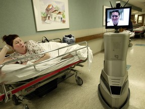 Patient Victoria Tierney reacts as she watches a robot, InTouch Health, go by in the hallway of an Emergency Department at Oakwood Hospital and Medical Center in Dearborn, Michigan, Tuesday, November 9, 2004.