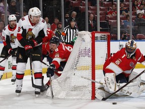 Ottawa Senators’ Cody Ceci (left) passes the puck out in front of Panthers goaltender Roberto Luongo at the BB&T Center in Sunrise, Fla., yesterday. The Sens won 3-2, their first victory since mid-February.