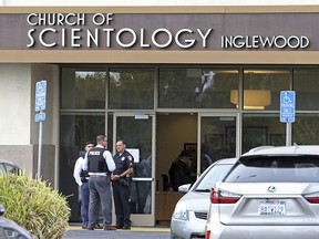 Police stand outside and investigators work inside the entrance to the Church of Scientology in Inglewood, Calif., Wednesday, March 27, 2019. (AP Photo/Reed Saxon)