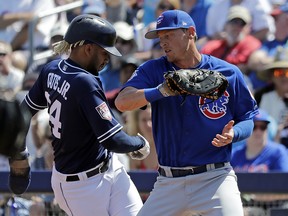 San Diego Padres' Fernando Tatis Jr., left, returns safely to first base on a pickoff attempt as Chicago Cubs first baseman Jim Adduci turns toward him during a spring training game Sunday, March 24, 2019, in Peoria, Ariz. (AP Photo/Elaine Thompson)