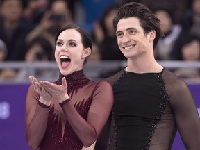 Canada's Tessa Virtue blows a kiss as Scott Moir looks on during victory ceremonies at the Pyeongchang Winter Olympics Tuesday, February 20, 2018 in Gangneung, South Korea. (THE CANADIAN PRESS/Paul Chiasson)