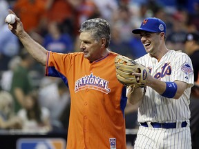 Former New York Mets pitcher Tom Seaver walks out with National League’s David before throwing out the first pitch before the MLB All-Star game, on Tuesday, July 16, 2013, in New York. (AP Photo/Matt Slocum)