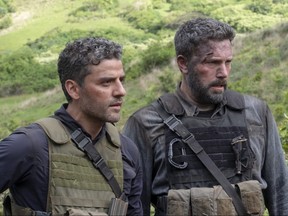 This image released by Netflix, shows Oscar Isaac, left and Ben Affleck in a scene from the film, "Triple Frontier."