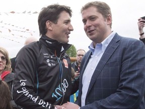 Prime Minister Justin Trudeau, left, shakes hand with Conservative Leader Andrew Scheer at the start of the Defi Pierre Lavoie, a 1000km bicycle trek, Thursday, June 14, 2018 in Saguenay Que.