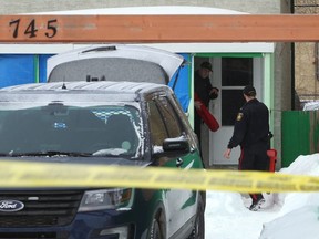 Police officers carry equipment into the rear of a home on McGee Street between Wellington and Notre Dame Avenues in Winnipeg on Mon., March 4, 2019. Police said they are investigating a homicide and there was also an ensuing officer-involved shooting. Kevin King/Winnipeg Sun/Postmedia Network