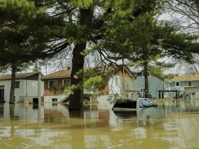 A car is submerged on a street in Ste-Marthe-sur-le-Lac on Sunday.