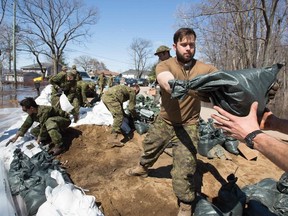Members of the Canadian armed forces help out with the sandbags in Constance Bay, west of Ottawa, Ontario, on April 28, 2019. - More than 5,000 people were told to quickly leave their homes near Montreal late Saturday and early Sunday after floodwaters breached a dike in rain-soaked eastern Canada. According to the latest government data, nearly 8,000 people have been forced by rising waters from their homes in Quebec, and about 6,000 homes have been flooded -- topping the 2017 toll during what was then the area's worst flooding in a half-century. ast week, both Montreal and the capital Ottawa declared states of emergency. In Fredericton, New Brunswick, crews have been busy hauling away driftwood and debris as waters start to recede.