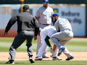 Jays pitcher Matt Shoemaker collides with As Matt Chapman on Saturday in Oakland. An MRI on Sunday revealed Shoemaker had torn his ACL and is done for the season.(Photo by Lachlan Cunningham/Getty Images)