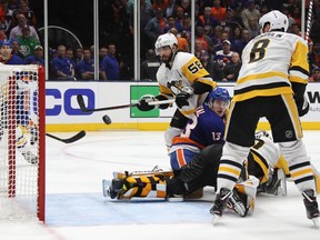 Kris Letang of the Pittsburgh Penguins watches the game winning shot from Josh Bailey of the New York Islanders (not shown) enter the net as Mathew Barzal (13) is checked in the crease in Game One of the Eastern Conference First Round during the 2019 NHL Stanley Cup Playoffs at NYCB Live's Nassau Coliseum on April 10, 2019 in Uniondale, New York. (Bruce Bennett/Getty Images)