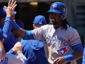 Blue Jays' Alen Hanson celebrates in the dugout during the team's sweep of the A's in Oakland.