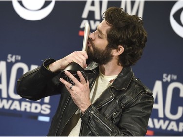Thomas Rhett poses in the press room as he kisses the award for male artist of the year at the 54th annual Academy of Country Music Awards at the MGM Grand Garden Arena on Sunday, April 7, 2019, in Las Vegas.