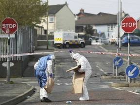 Police forensic officers at the scene in Londonderry, Northern Ireland, Friday April 19, 2019, following the death of 29-year-old journalist Lyra McKee who was shot and killed during overnight rioting. (Brian Lawless/PA via AP)