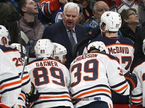 Edmonton Oilers head coach Ken Hitchcock, back, talks to his players after they gave up three goals to the Colorado Avalanche in the second period of an NHL hockey game Tuesday, April 2, 2019, in Denver.