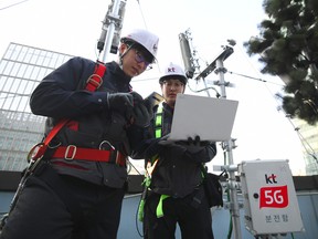 Technicians of South Korean telecom operator KT check an antenna for the 5G mobile network service on the rooftop of a building in Seoul on April 4, 2019. (JUNG YEON-JE/AFP/Getty Images)