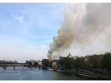 Flames and smoke are seen billowing from the roof at Notre-Dame Cathedral in Paris on April 15, 2019. - A fire broke out at the landmark Notre-Dame Cathedral in central Paris, potentially involving renovation works being carried out at the site, the fire service said.Images posted on social media showed flames and huge clouds of smoke billowing above the roof of the gothic cathedral, the most visited historic monument in Europe.