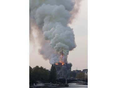 Smokes ascends as flames rise during a fire at the landmark Notre Dame Cathedral in central Paris on April 15, 2019.