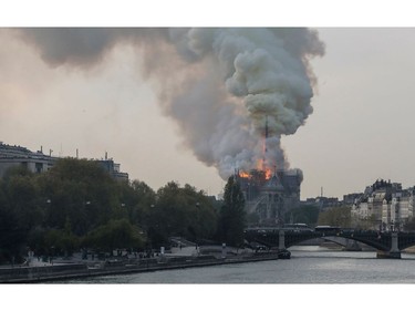 Smokes ascends as flames rise during a fire at the landmark Notre Dame Cathedral in central Paris on April 15, 2019.