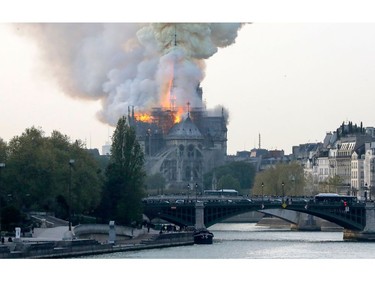 Smokes ascends as flames rise during a fire at the landmark Notre Dame Cathedral in central Paris on April 15, 2019.