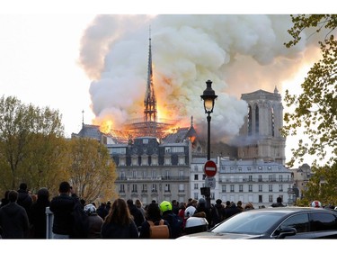 Seen from across the Seine River, smoke and flames rise during a fire at the landmark Notre-Dame Cathedral in central Paris on April 15, 2019.