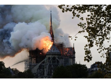 Flames and smoke are seen billowing from the roof at Notre Dame Cathedral in Paris on April 15, 2019. - A fire broke out at the landmark Notre-Dame Cathedral in central Paris, potentially involving renovation works being carried out at the site, the fire service said.