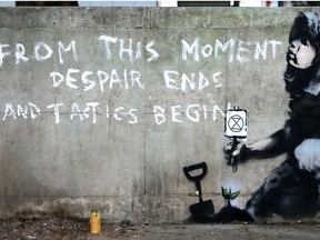 Graffiti artwork, suspected to have been created by the British street artist Banksy, is pictured opposite the environmental protest group Extinction Rebellion's camp at Marble Arch in London on April 26, 2019.