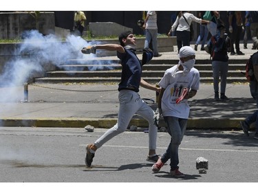 Opposition demonstrators clash with soldiers loyal to Venezuelan President Nicolas Maduro after troops joined opposition leader Juan Guaido in his campaign to oust Maduro's government, in the surroundings of La Carlota military base in Caracas on April 30, 2019.
