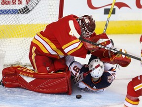 Edmonton Oilers Connor McDavid collides with Mike Smith of the Calgary Flames during an NHL game at the Scotiabank Saddledome in Calgary on Saturday, April 6, 2019.