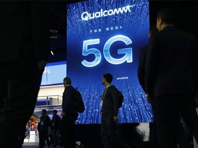 In this Jan. 9, 2019, file photo a sign advertises 5G at the Qualcomm booth at CES International in Las Vegas. Apple and mobile chip maker Qualcomm have settled a bitter financial dispute centered on some of the technology that enables iPhones to connect to the internet.