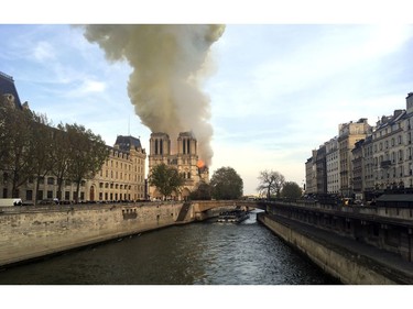 Notre Dame cathedral is burning in Paris, Monday, April 15, 2019. Massive plumes of yellow brown smoke is filling the air above Notre Dame Cathedral and ash is falling on tourists and others around the island that marks the center of Paris.