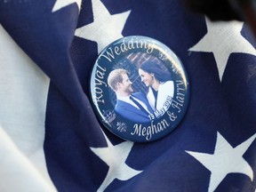 In this Thursday, May 17, 2018 file photo, a badge showing Prince Harry and Meghan Markle is pinned onto a U.S. flag in Windsor, England.