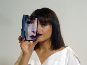 A model holds a Samsung Galaxy Fold smartphone to her face, during a media preview event in London, Tuesday April 16, 2019.