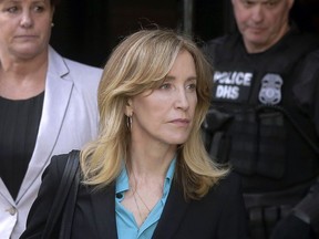 In this April 3, 2019 file photo, actress Felicity Huffman arrives at federal court in Boston to face charges in a nationwide college admissions bribery scandal. In a court filing on Monday, April 8, 2019, Huffman agreed to plead guilty in the cheating scam.
