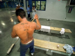 A Corcran State Prison inmate sweeps up hair after fellow inmates received hair cuts in one of the cell blocks Tuesday afternoon in Corcoran. (Ryan Krauter)