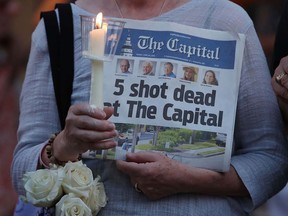 A women holds the Capital Gazette newpaper during a candlelight vigil to honor the five people who were killed in Annapolis, Maryland. (Mark Wilson/Getty Images)