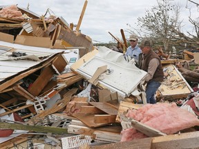 Roman Brown, left and Sam Crawford, right move part of a shower wall out of their way as they help a friend look for their medicine in their destroyed home Sunday, April 14, 2019, along Seely Dr. outside of Hamilton, Miss. after an apparent tornado touched down Saturday, April, 13, 2019.